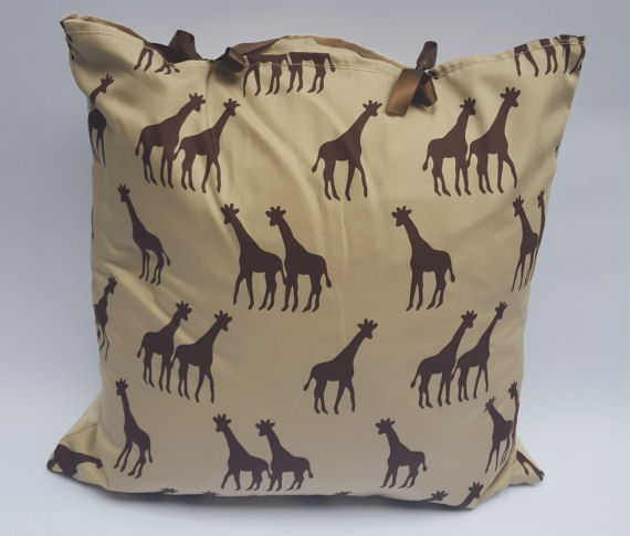 A Brown Giraffe Design Cushion on Beige finished with Bows