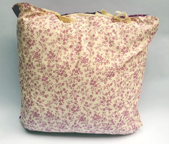 A Floral Pattern Cushion on Cream with a Purple Reverse with Spots, finished with Bows