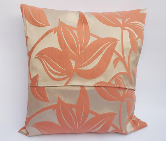 A Handmade Floral Cushion in Coral on Beige.