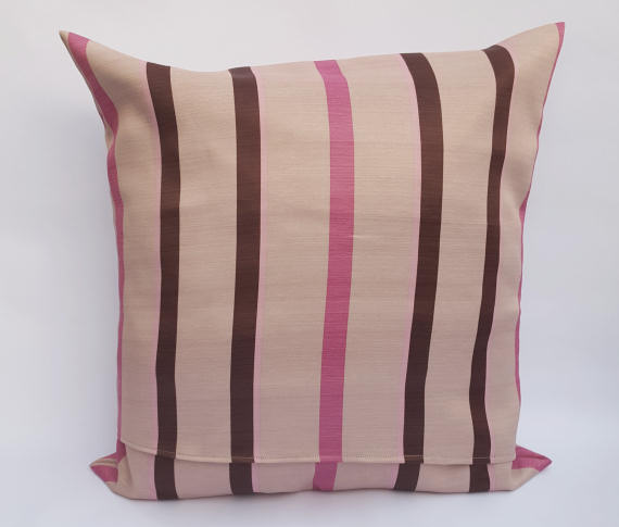 A Handmade Pink and Brown Striped Cushion on Beige.
