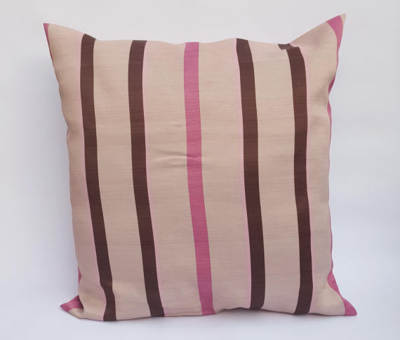 A Handmade Pink and Brown Striped Cushion on Beige.